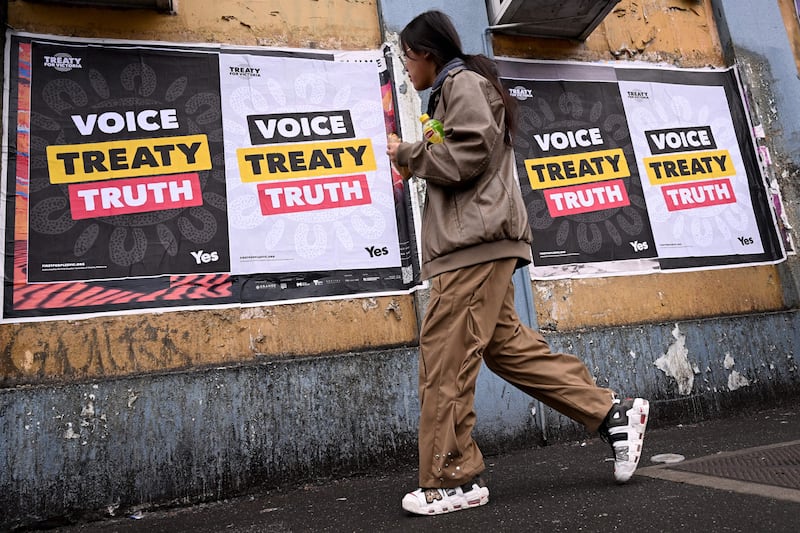 A woman walks past posters advocating for an Aboriginal voice and treaty ahead of an upcoming referendum, in Melbourne on August 30, 2023. Prime Minister Anthony Albanese announced Australia will hold a historic Indigenous rights referendum on October 14 setting up a defining moment in the nation's relationship with its Aboriginal minority. (Photo by William WEST / AFP) (Photo by WILLIAM WEST/AFP via Getty Images)